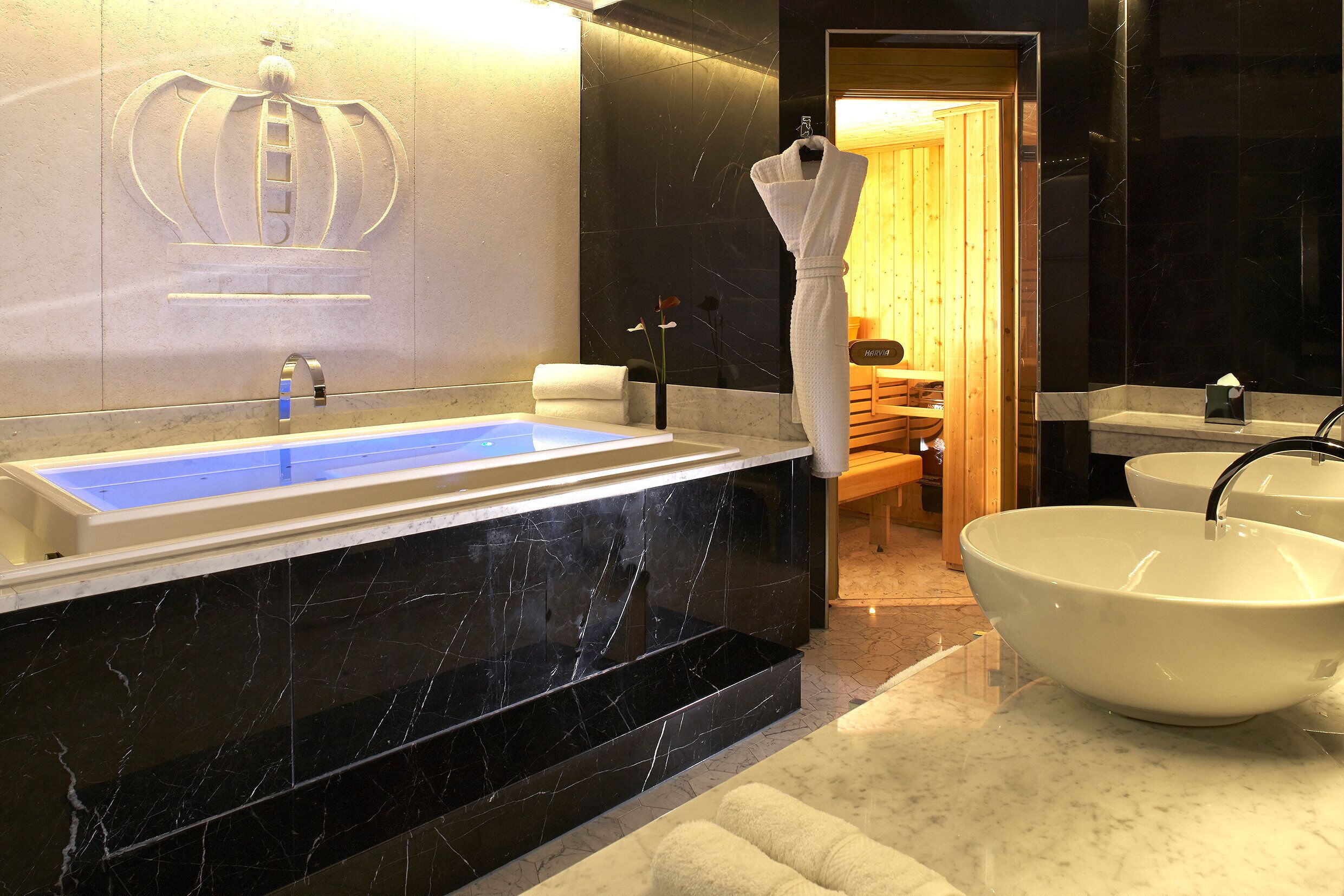A modern bathroom with a large bathtub, a white sink, and a towel rack.