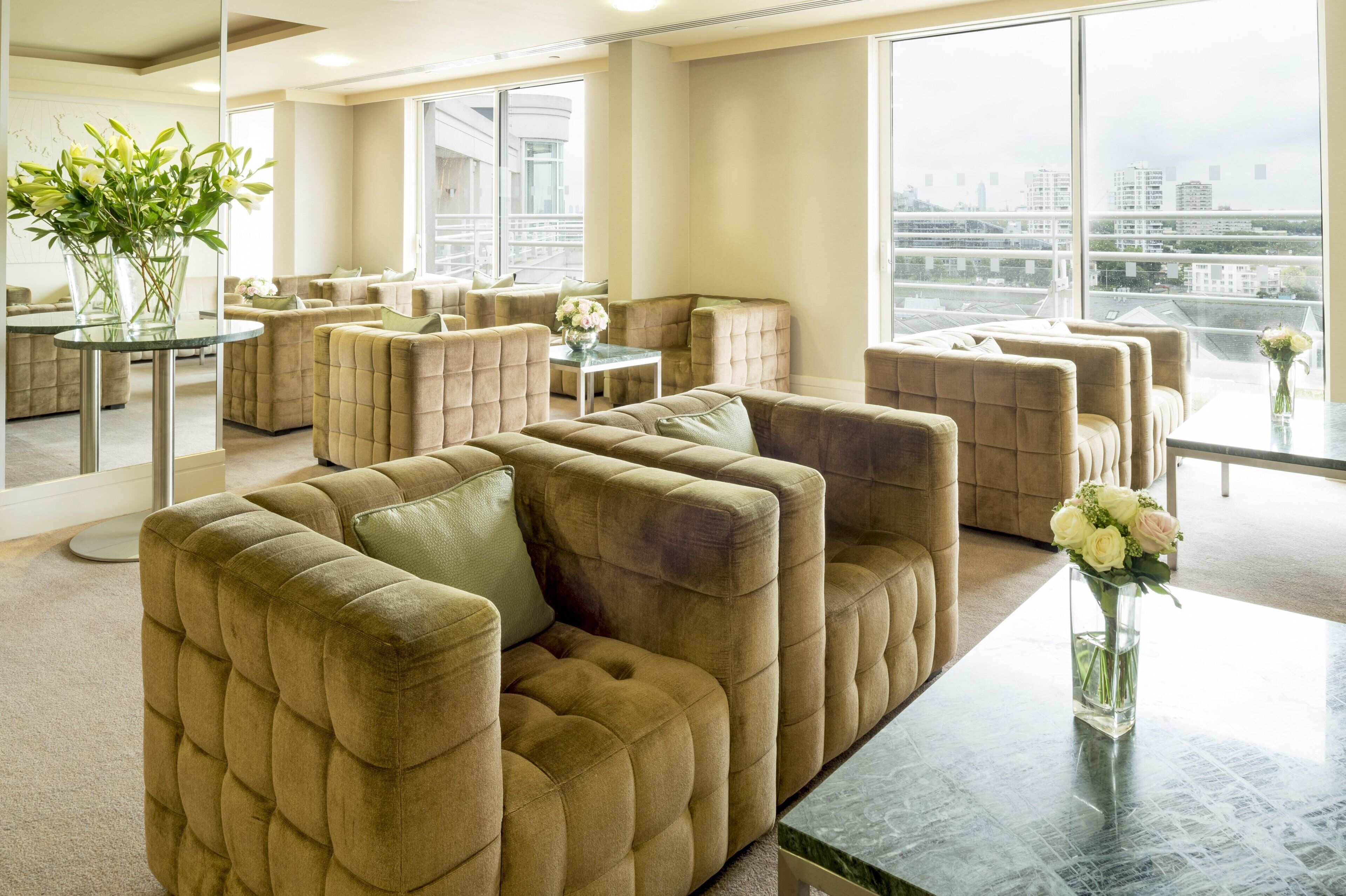A modern lounge area with plush seating and large windows offering city views.