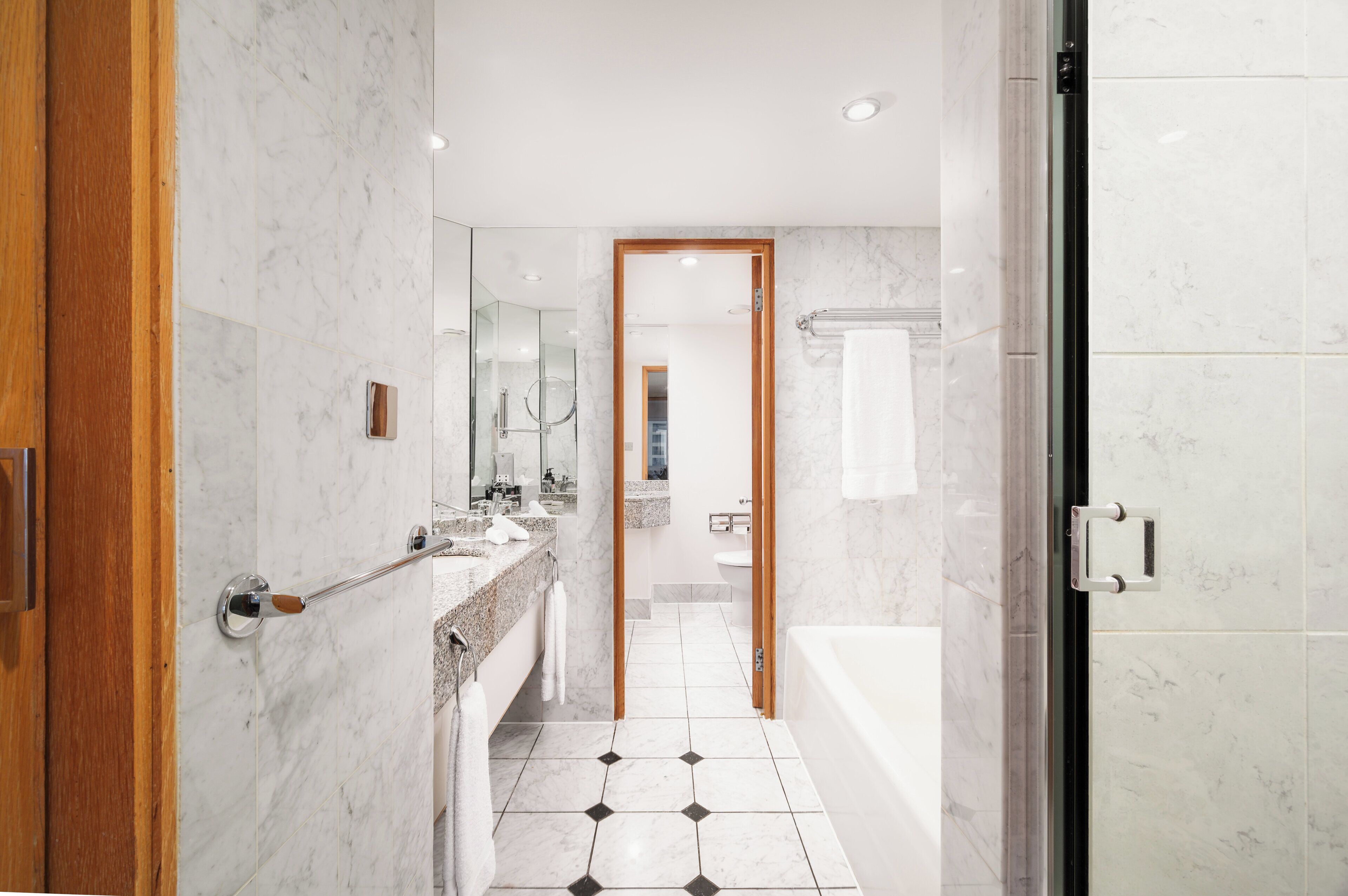 Une salle de bain moderne avec un sol en marbre, une baignoire et un espace douche.