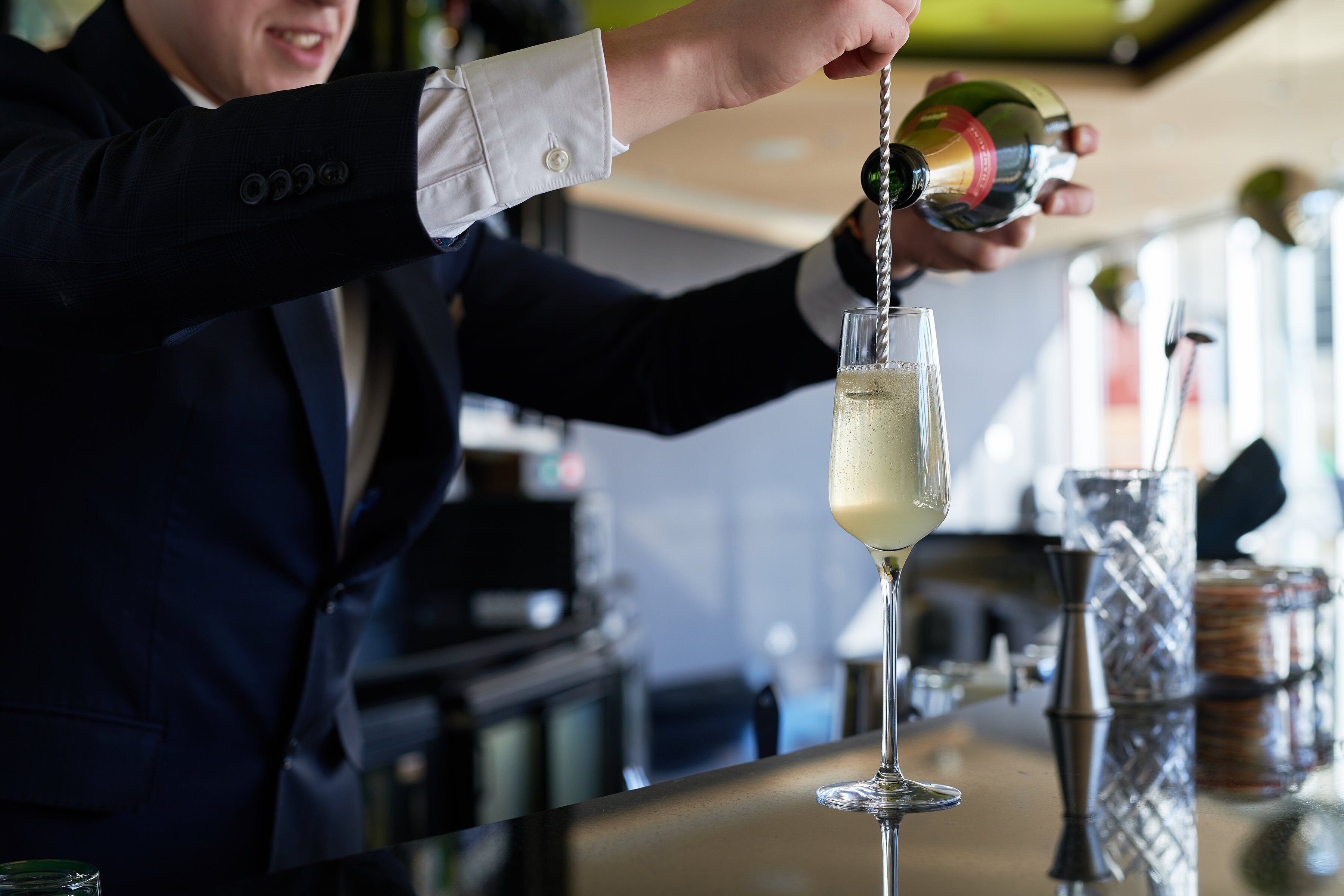A person pouring a drink into a glass.