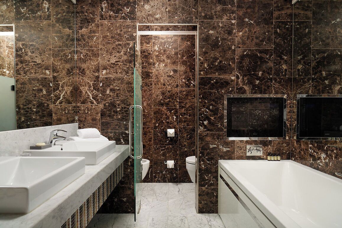 A modern bathroom with two sinks, a bathtub, and a glass shower enclosure.