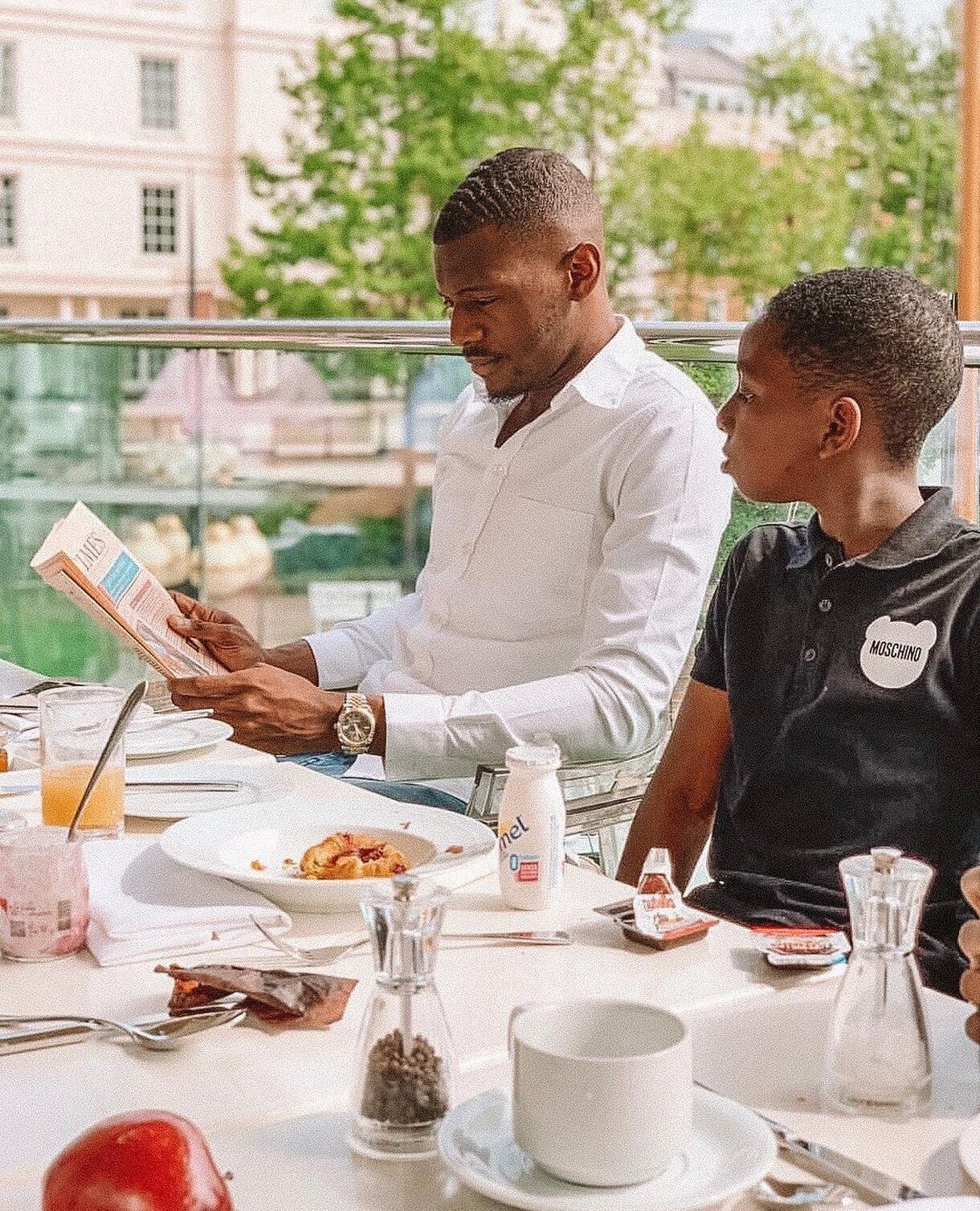 A dining table with a newspaper, a glass of orange juice, and a bottle of milk.