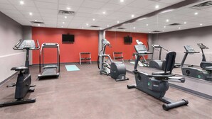 Ein Fitnessstudio mit Laufbändern, Crosstrainern und Ergometer.