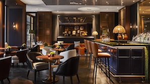 A modern bar area with seating and a bar counter. - Rosewood Villa Magna (Madrid)