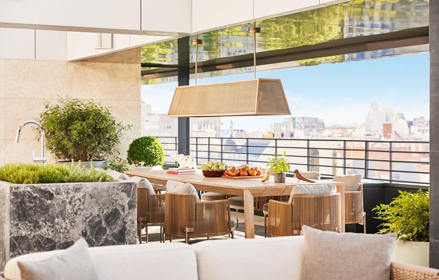 Una terraza moderna en la azotea con zona de comedor, asientos y vistas a la ciudad.