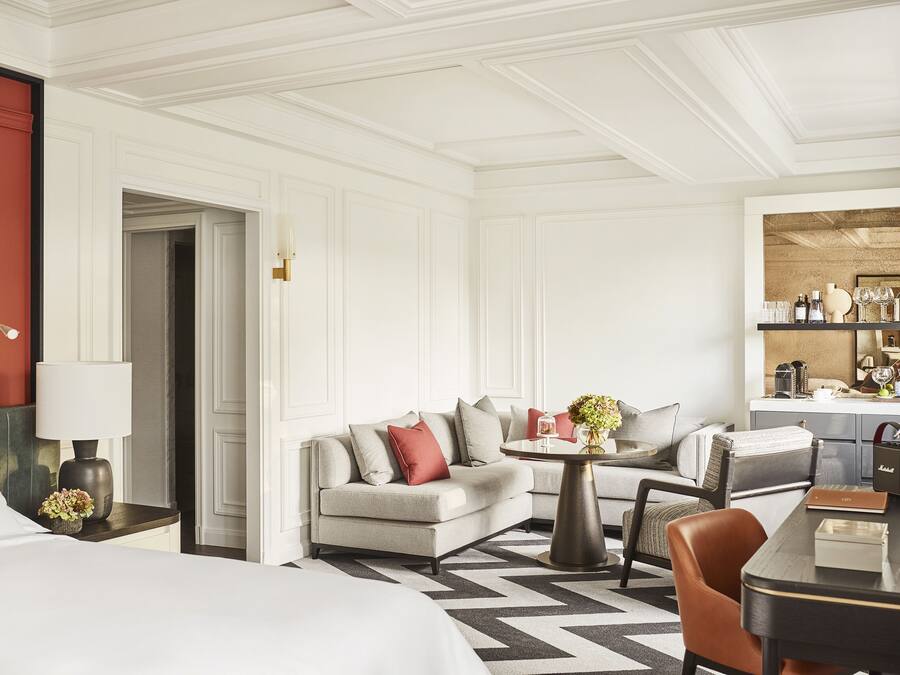Une chambre d’hôtel comprenant un lit, un canapé, une table à manger et un petit coin cuisine.