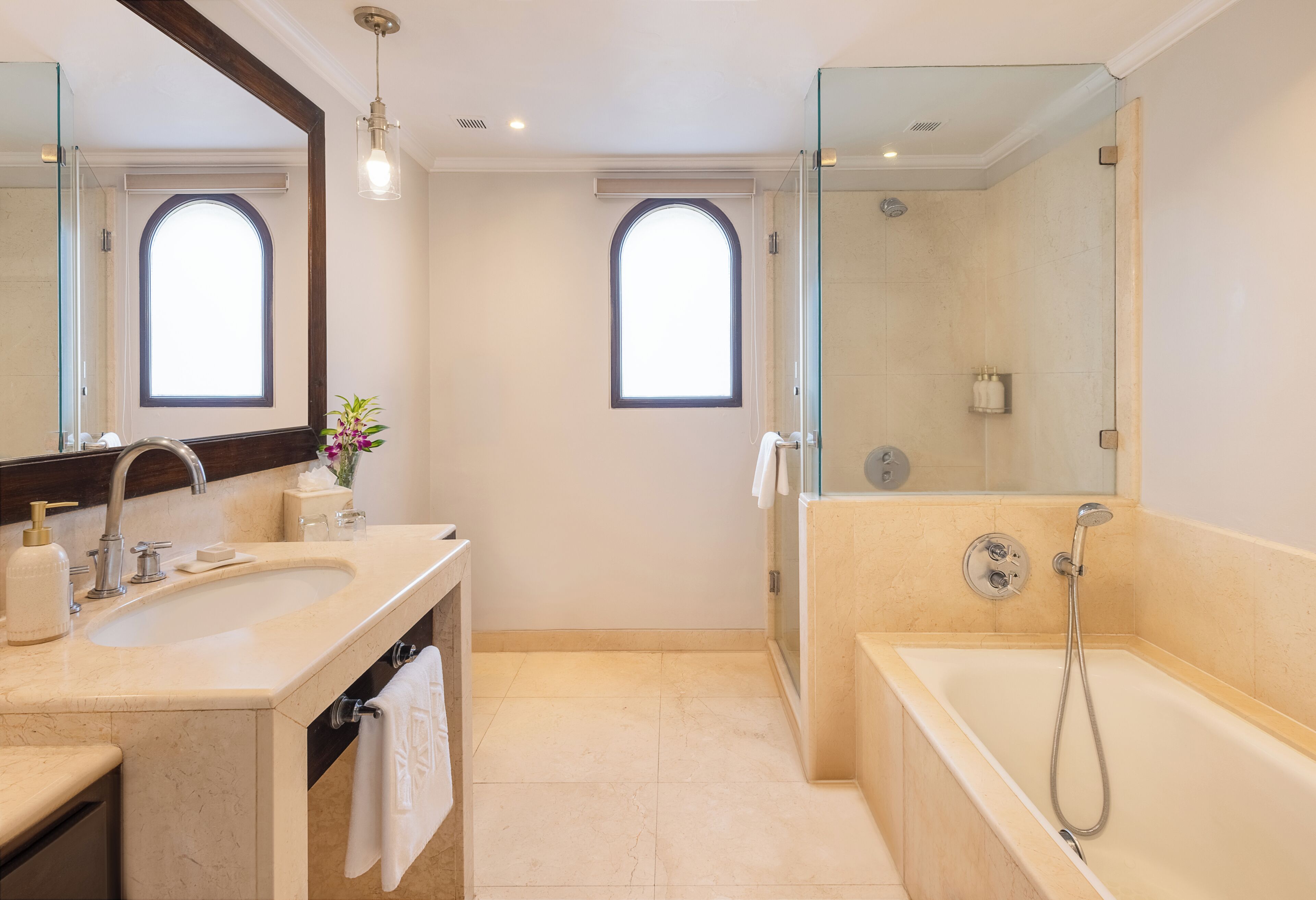Un baño moderno con un espejo grande, una bañera y una ducha.