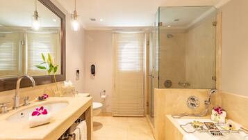 A modern bathroom with a large mirror, two sinks, a shower, and a toilet.