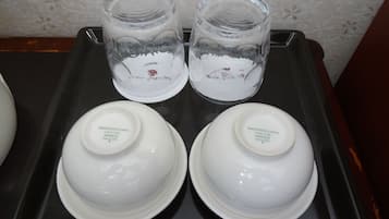A tray with two glass jars and two white bowls with lids.