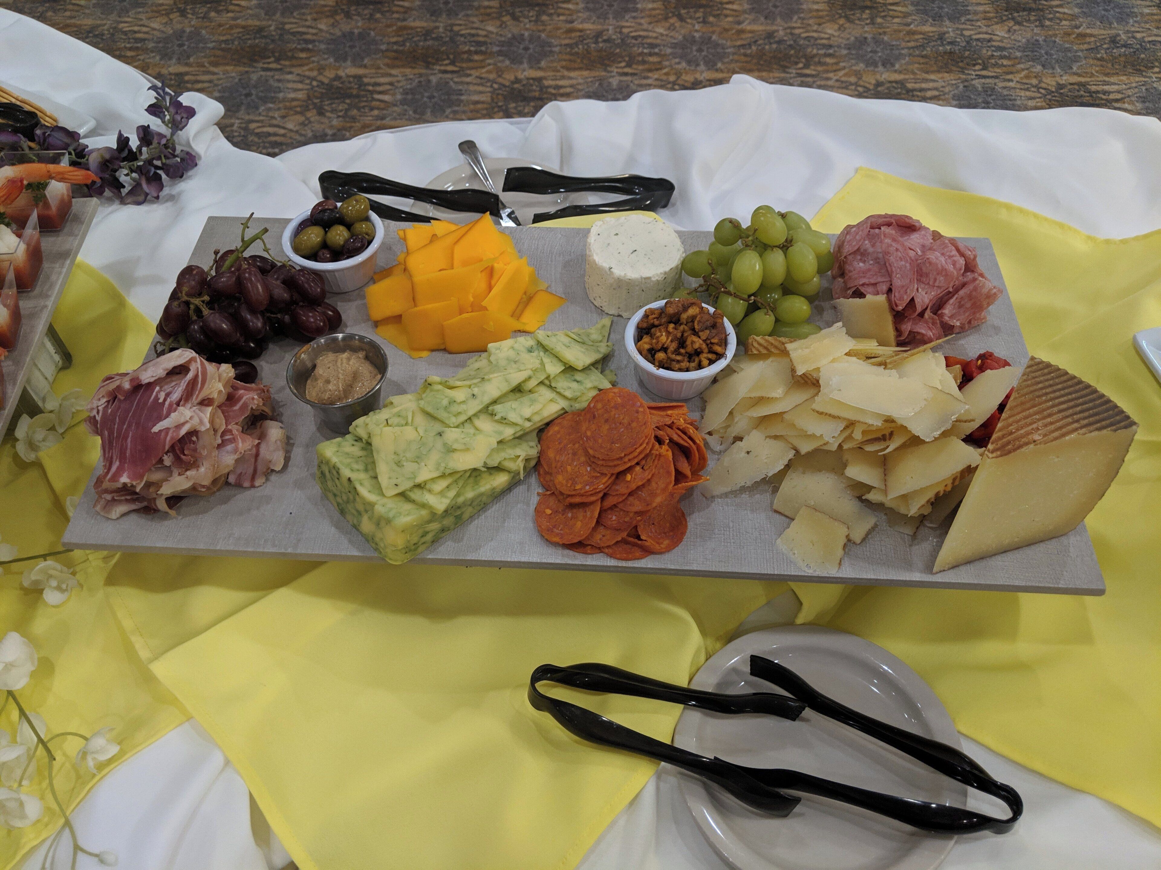 Une planche de charcuterie avec divers fromages, viandes et accompagnements.