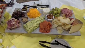 A charcuterie board with various cheeses, meats, and accompaniments.