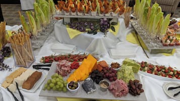 A buffet table with various food items and utensils.