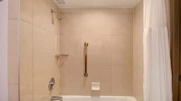 A modern bathroom with a walk-in shower, grab bars, and a bathtub.