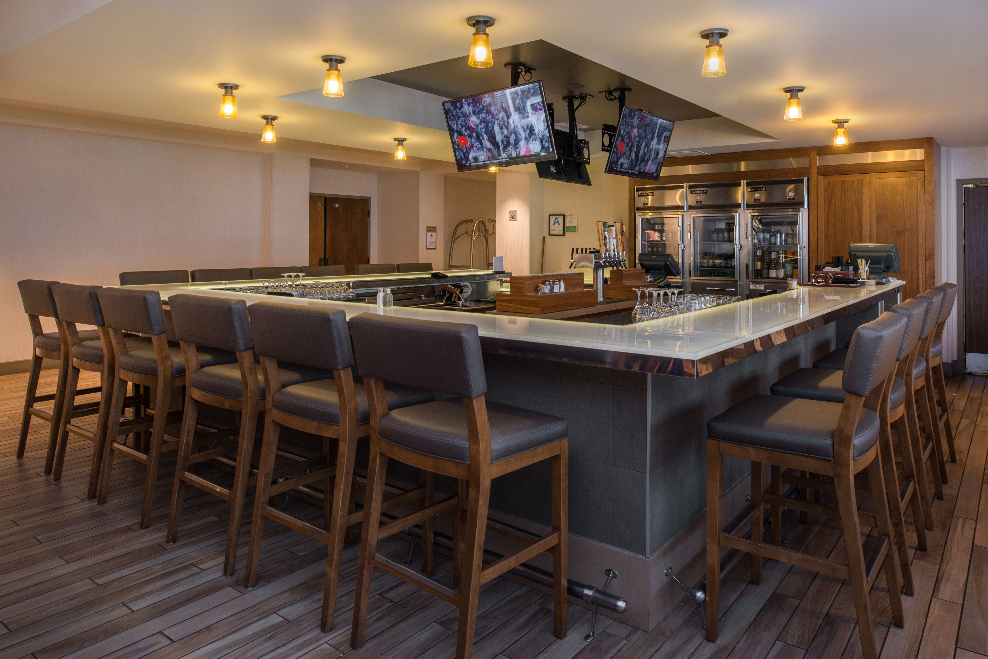A modern kitchen with a large island, bar stools, and built-in appliances.