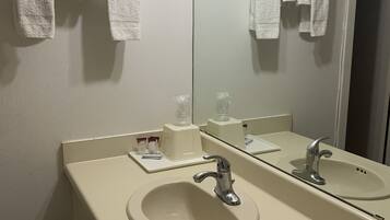 Een badkamer met twee wasbakken, een spiegel en handdoeken die aan de muur hangen.