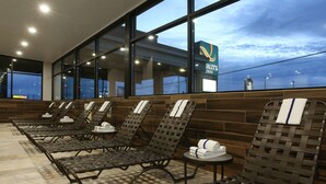 A hotel relaxation area with lounge chairs and a view of the city skyline. - Quality Inn Oakwood (Spokane)