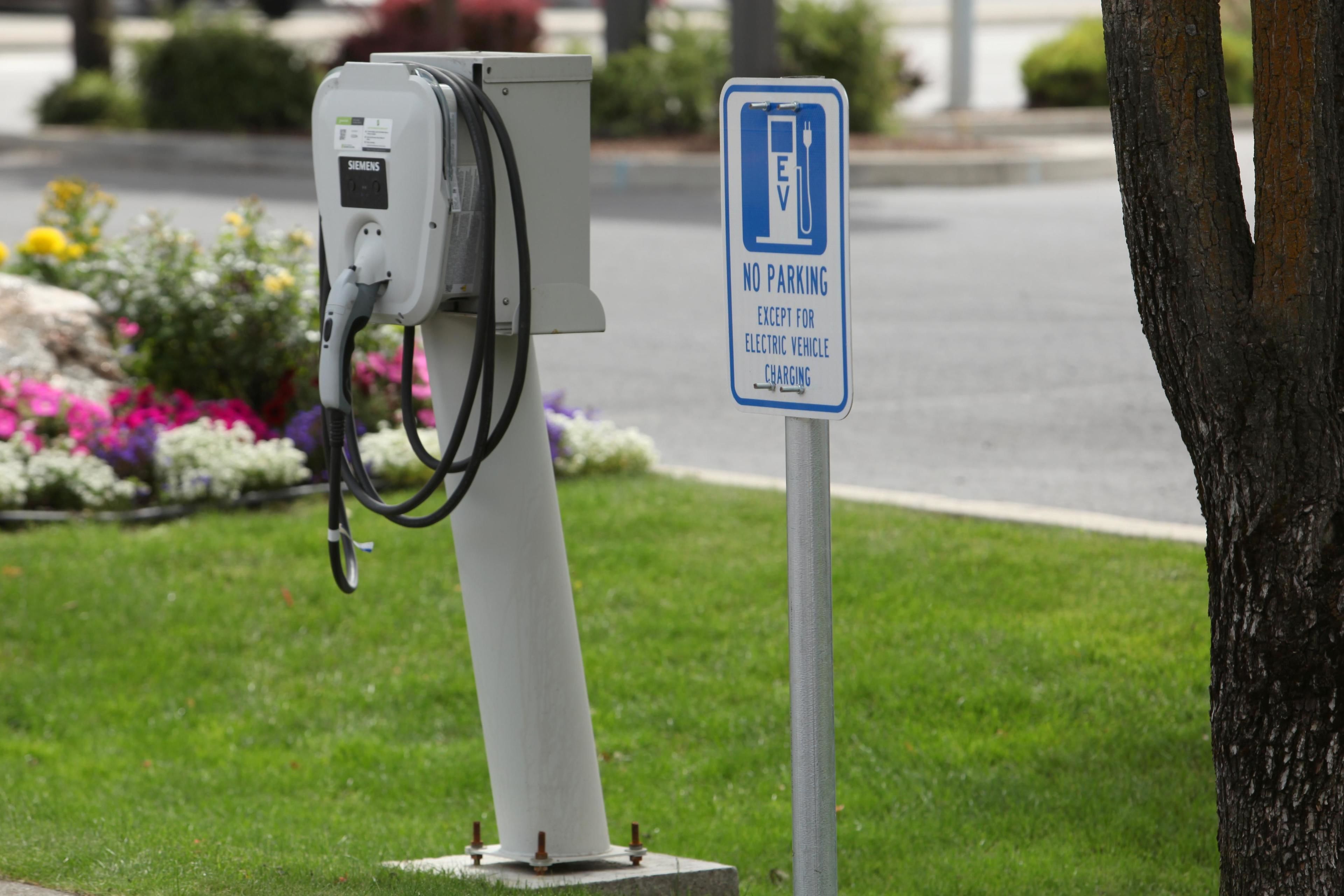 An electric vehicle charging station with a sign indicating no parking except for electric vehicle charging.