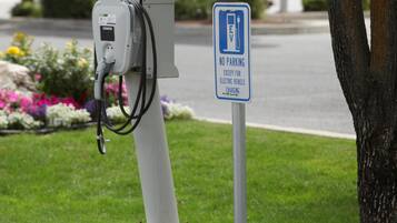 An electric vehicle charging station with a sign indicating no parking except for electric vehicle charging.