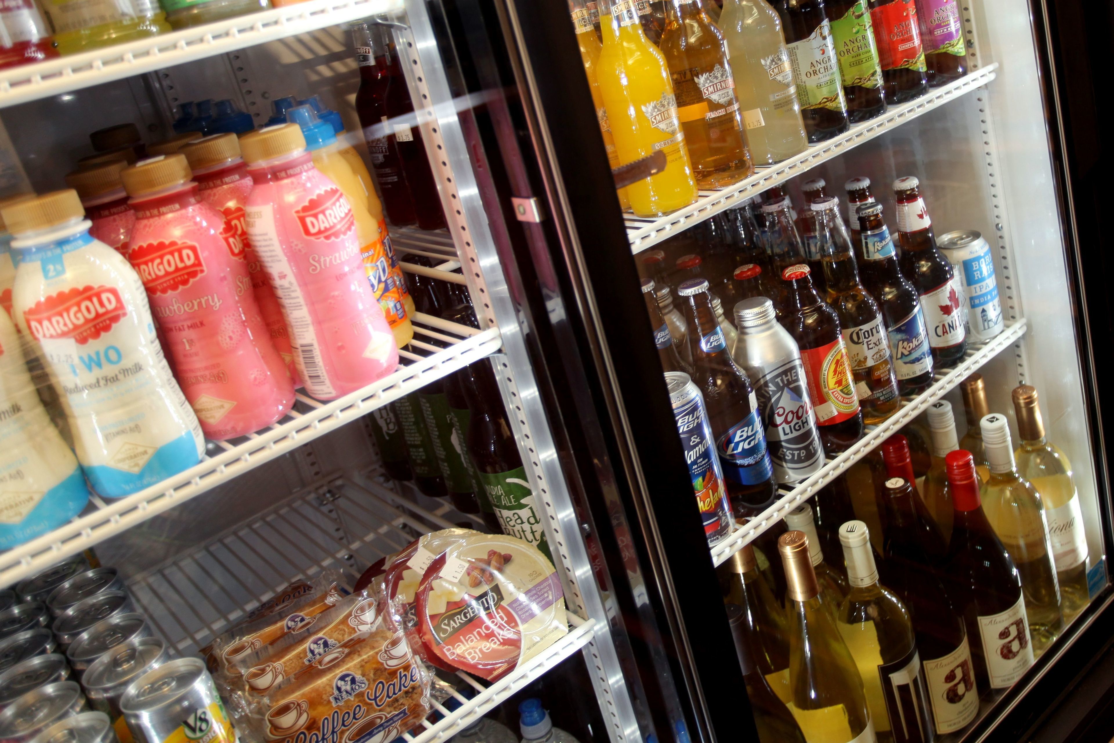 A refrigerated display case with various beverages including milk, juice, and beer.
