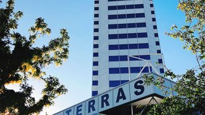 A high-rise hotel building with the name 'NOVOTEL' and 'TERRAS' visible on its facade.
