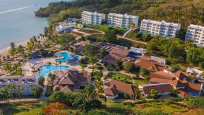 Un complexe hôtelier comprenant plusieurs bâtiments, une piscine et une plage.