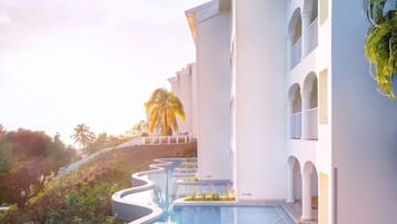 Un resort con piscina, edificios blancos y palmeras.