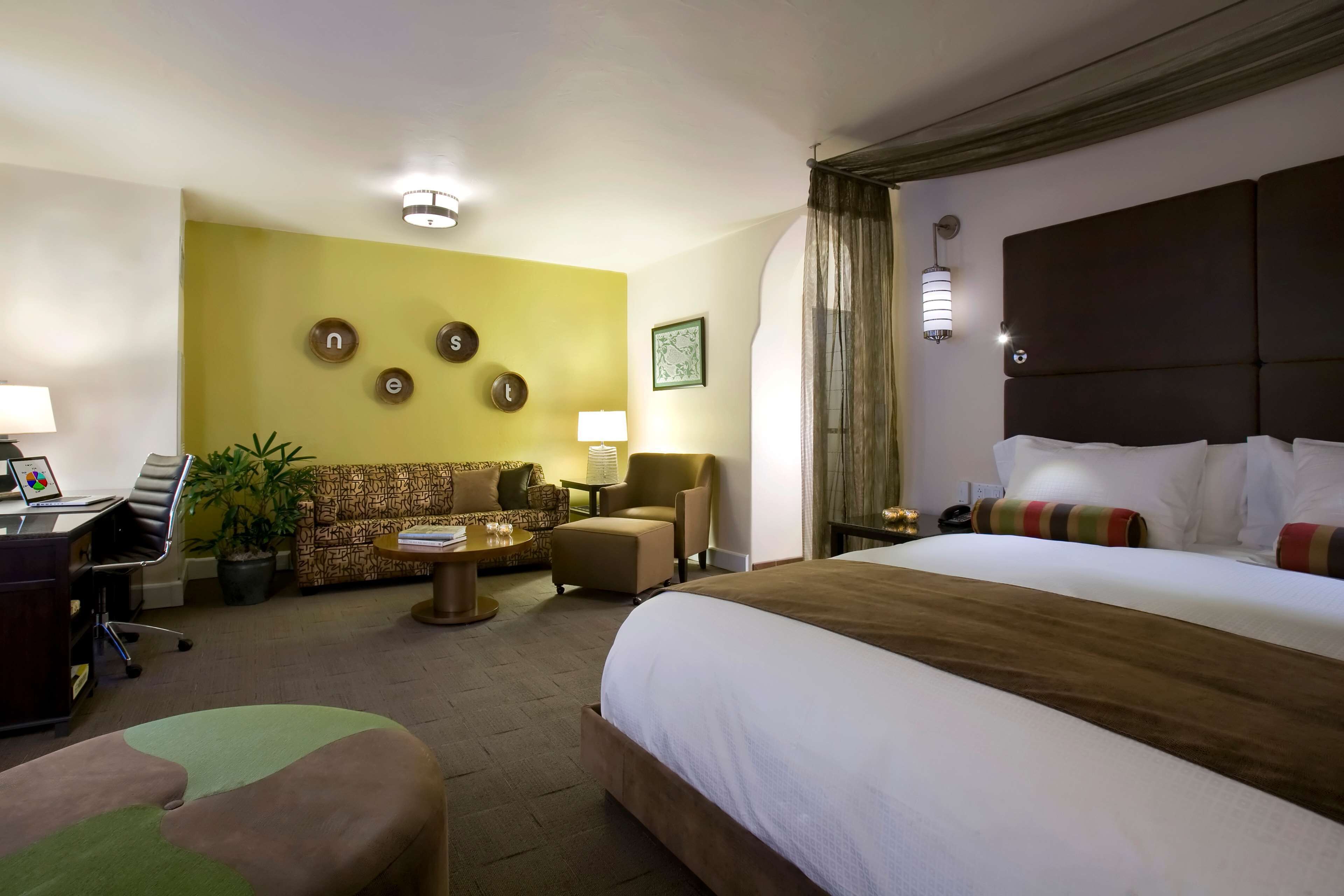 Una habitación de hotel con una cama grande, un sofá, un escritorio y una silla.
