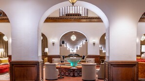 A lobby with a central fountain, arched ceilings, and a seating area with sofas and armchairs. - Hotel Andaluz Albuquerque, Curio Collection by Hilton (Albuquerque)