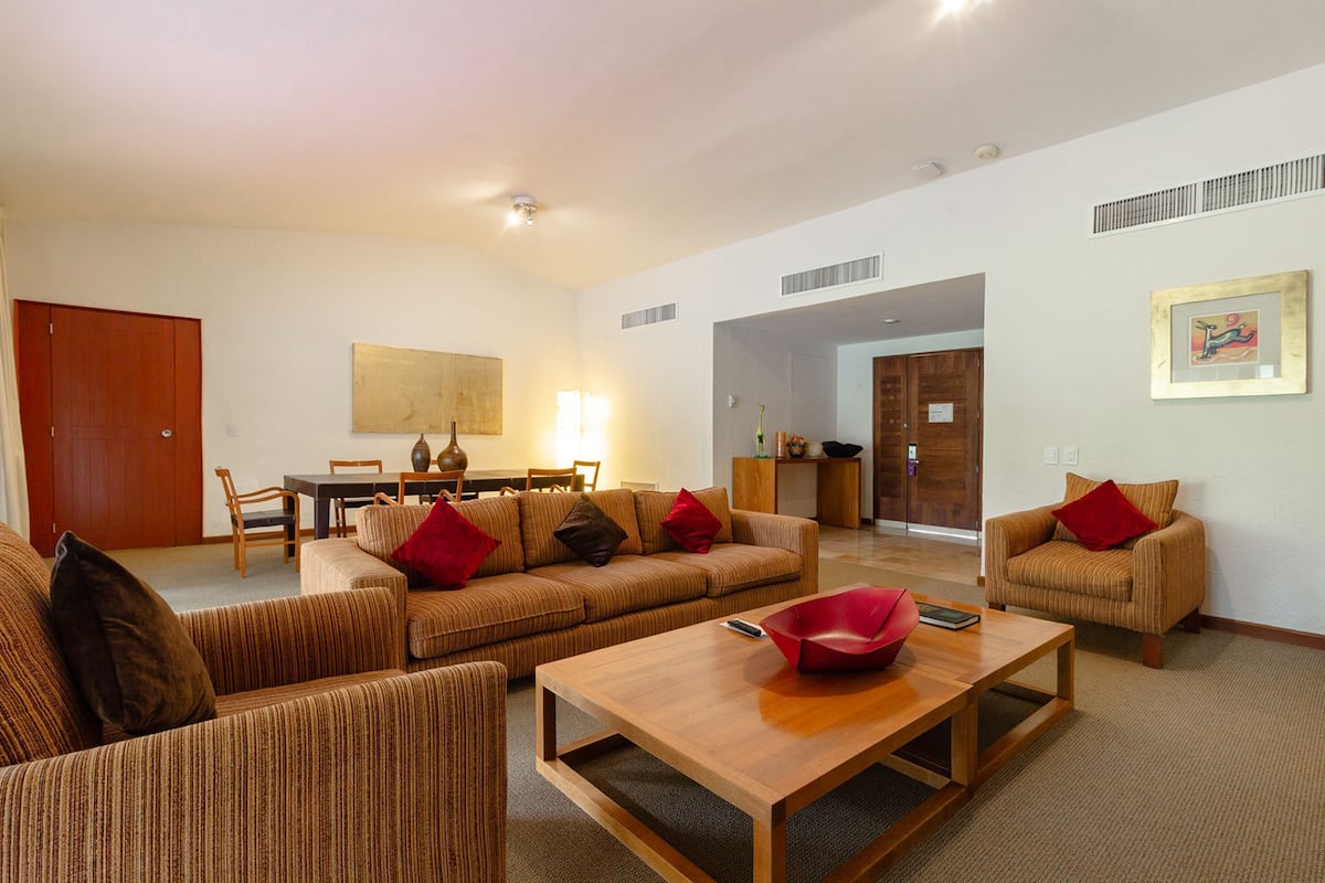Ein geräumiges Wohnzimmer mit einer Sofagarnitur, einem Holztisch und einem Essbereich mit Tisch und Stühlen.