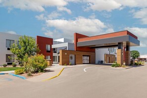 Stylish building with a flat roof entrance and beautifully landscaped surroundings.