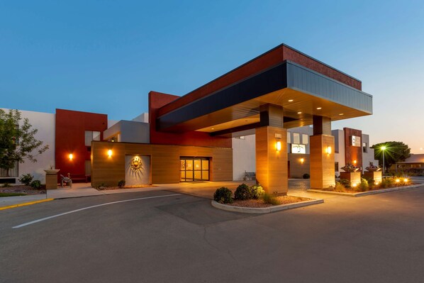 Experience the sleek entrance of this hotel, marked by a glass door and stairs leading up to it.