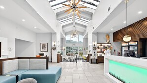 A modern hotel lobby with a reception desk, seating area, and a view of the mountains. - Holiday Inn Clarkston - Lewiston by IHG (Clarkston)