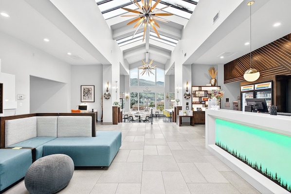 A modern hotel lobby with a reception desk, seating area, and a view of the mountains. - Holiday Inn Clarkston - Lewiston by IHG (Clarkston)