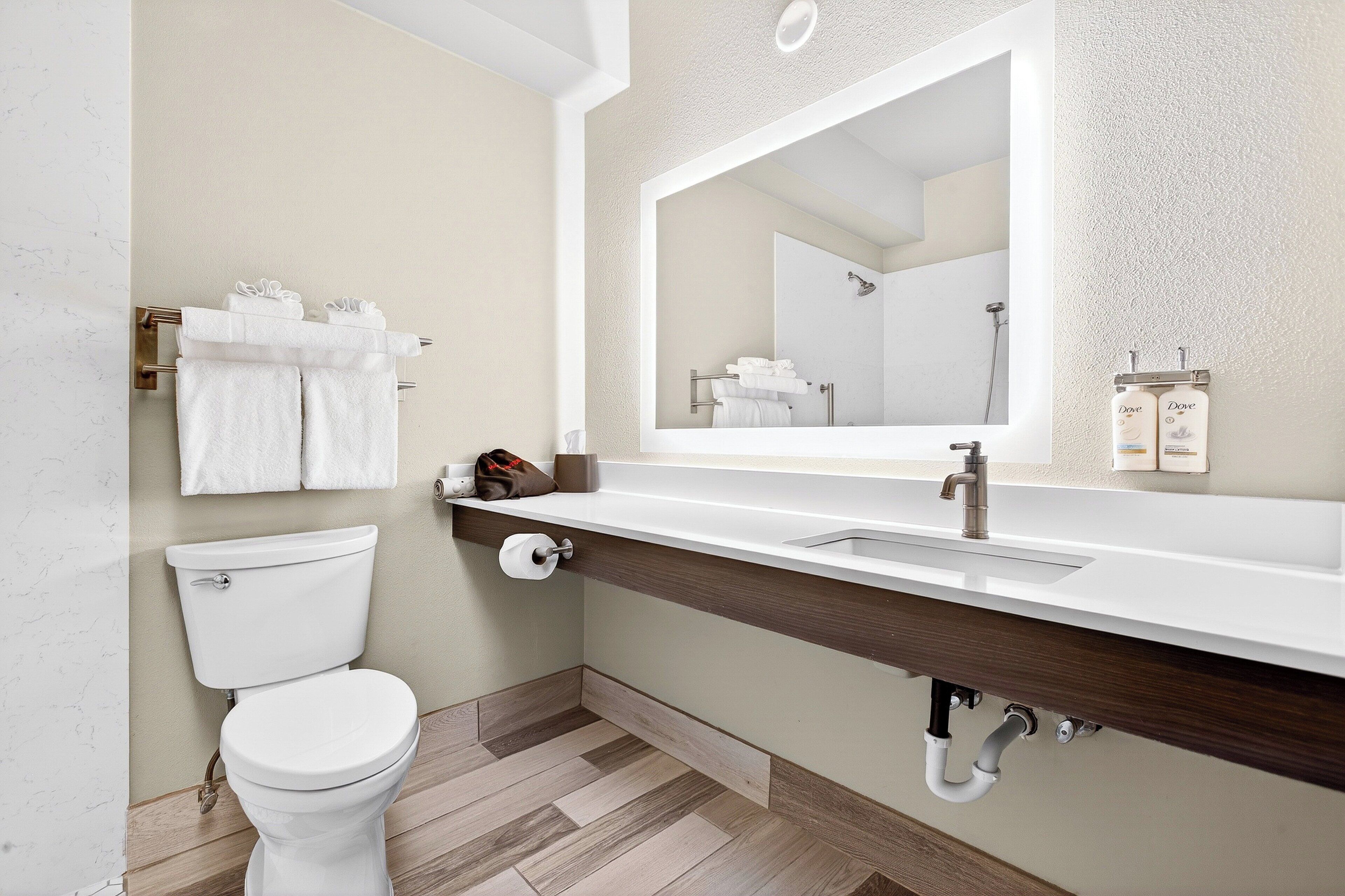 Une salle de bain moderne avec des toilettes, un lavabo et un miroir.
