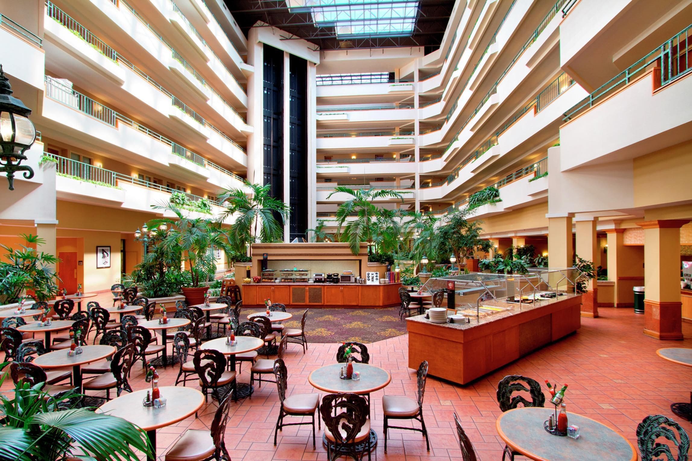A multi-level atrium with dining areas, a central bar, and multiple floors with balconies.