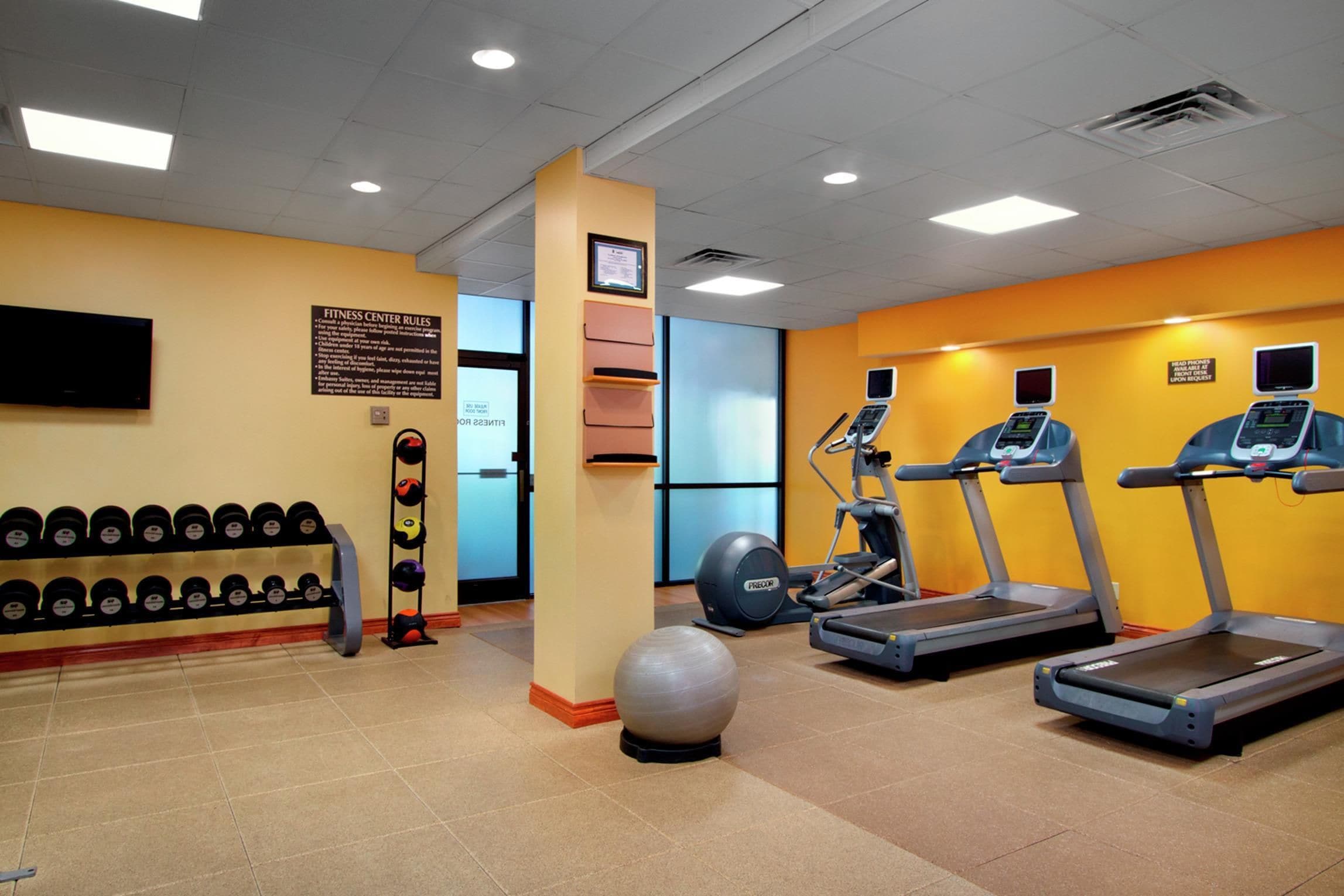 A fitness center with treadmills, a stationary bike, and a weight rack.