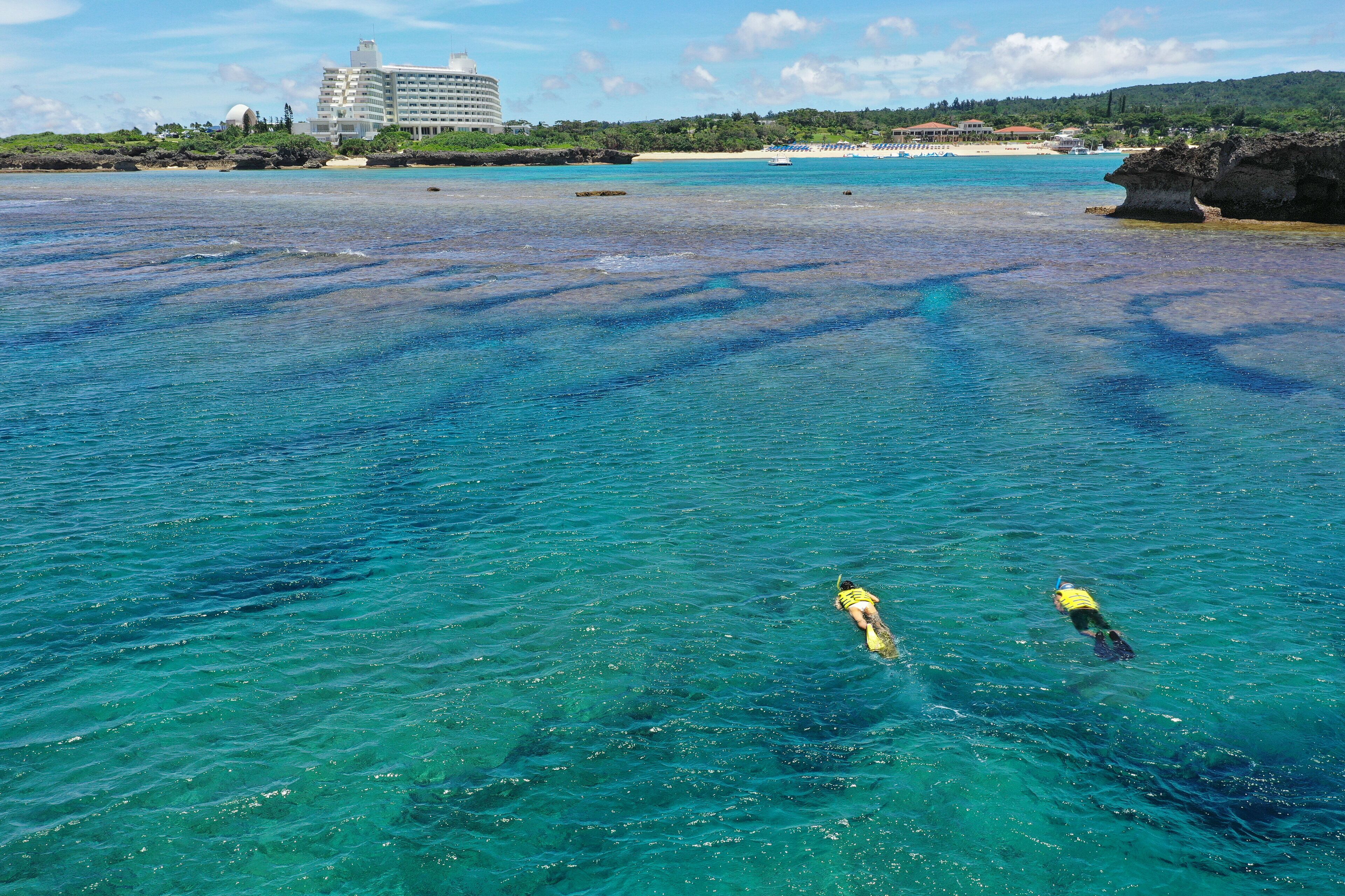 A clear view of a beach with a hotel in the background.