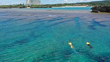 A clear view of a beach with a hotel in the background.