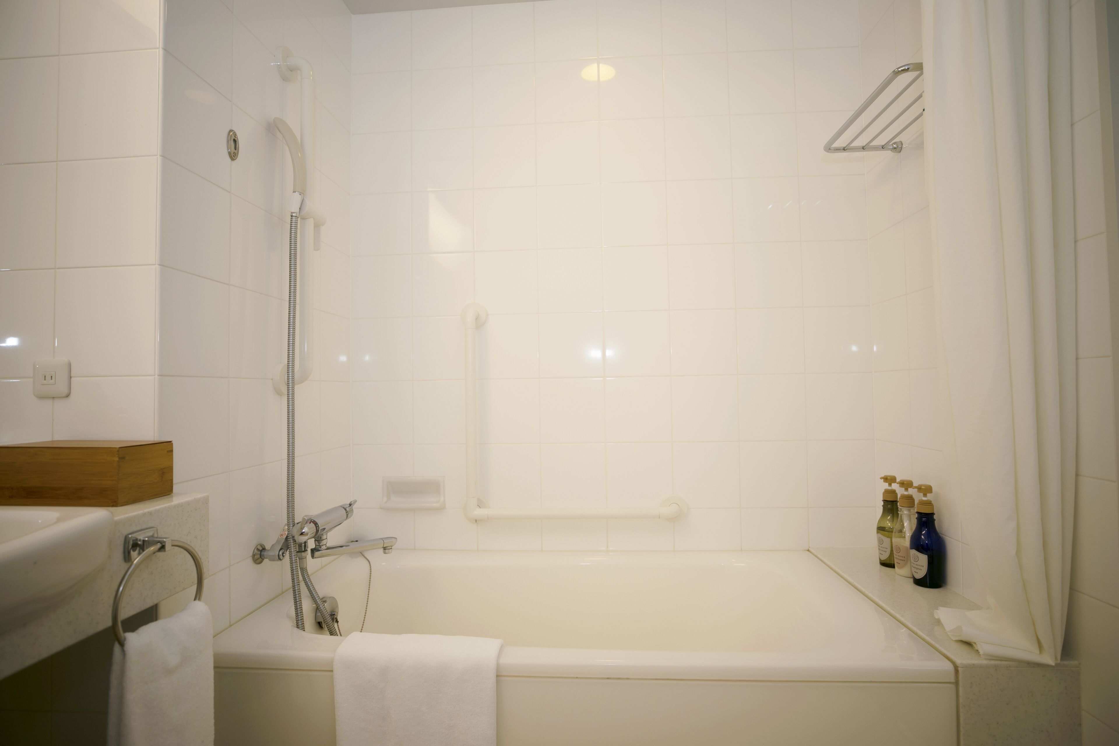 Une salle de bain avec une baignoire, une douche, un lavabo et une boîte en bois posée sur le comptoir.