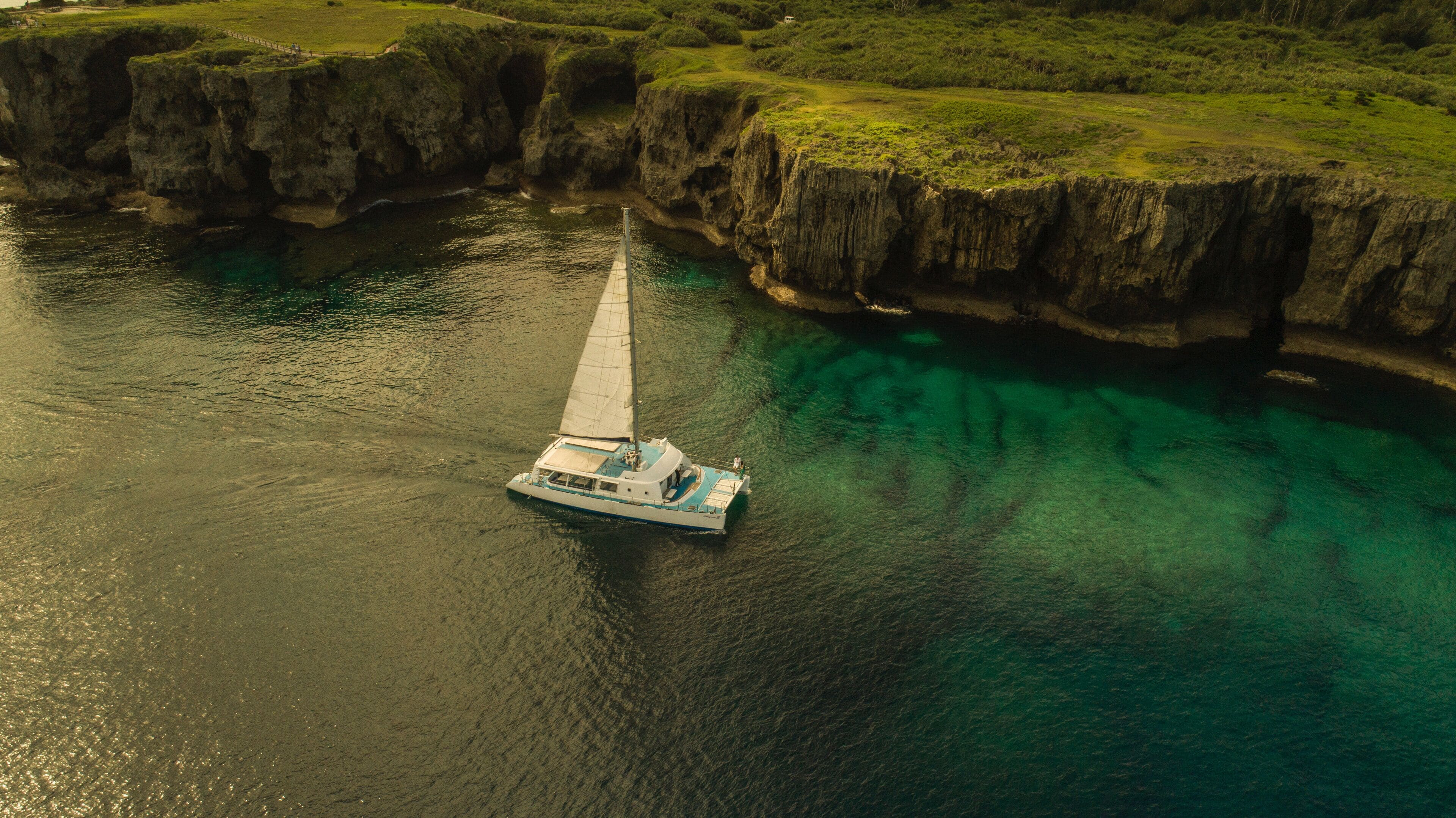 A boat on calm waters near a rocky coastline.