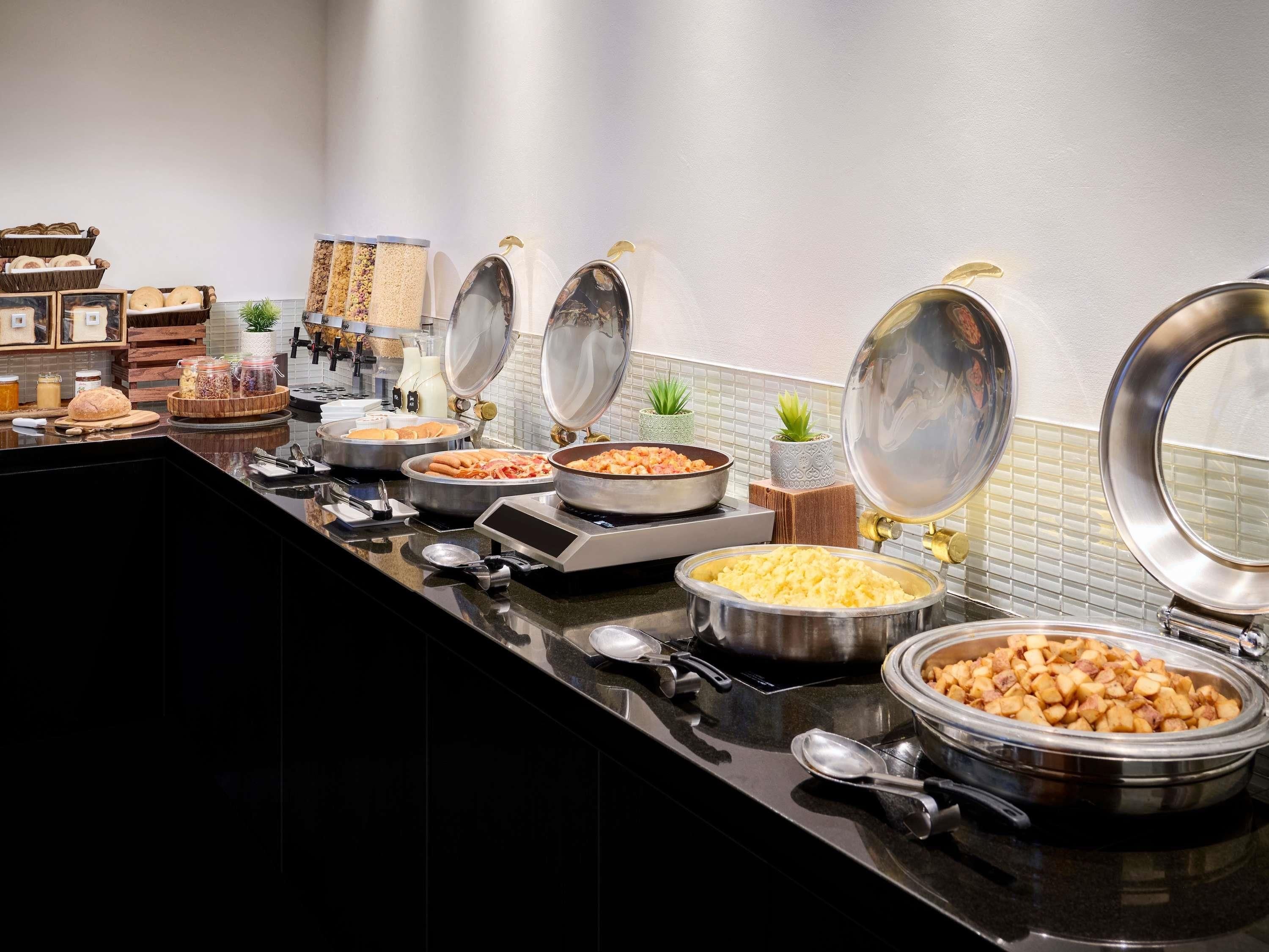 En buffet med forskellige spisemuligheder, herunder pasta, salater og brød.