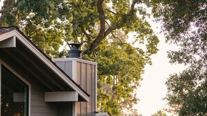 A modern house with a deck, outdoor furniture, and a chimney. - Silverado Resort (Napa)