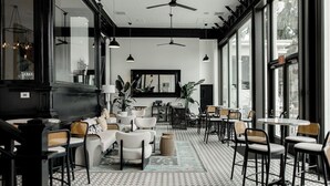 Un interior moderno con zona de bar, asientos y ventanas amplias.