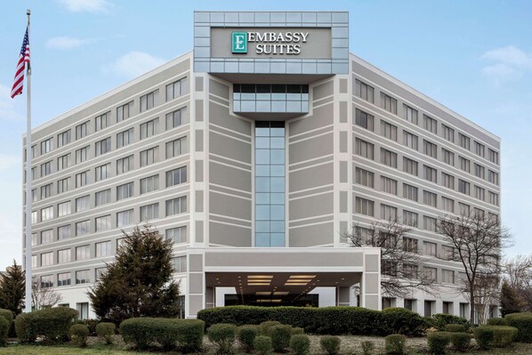 A modern building with a sign reading "Embassy Suites."