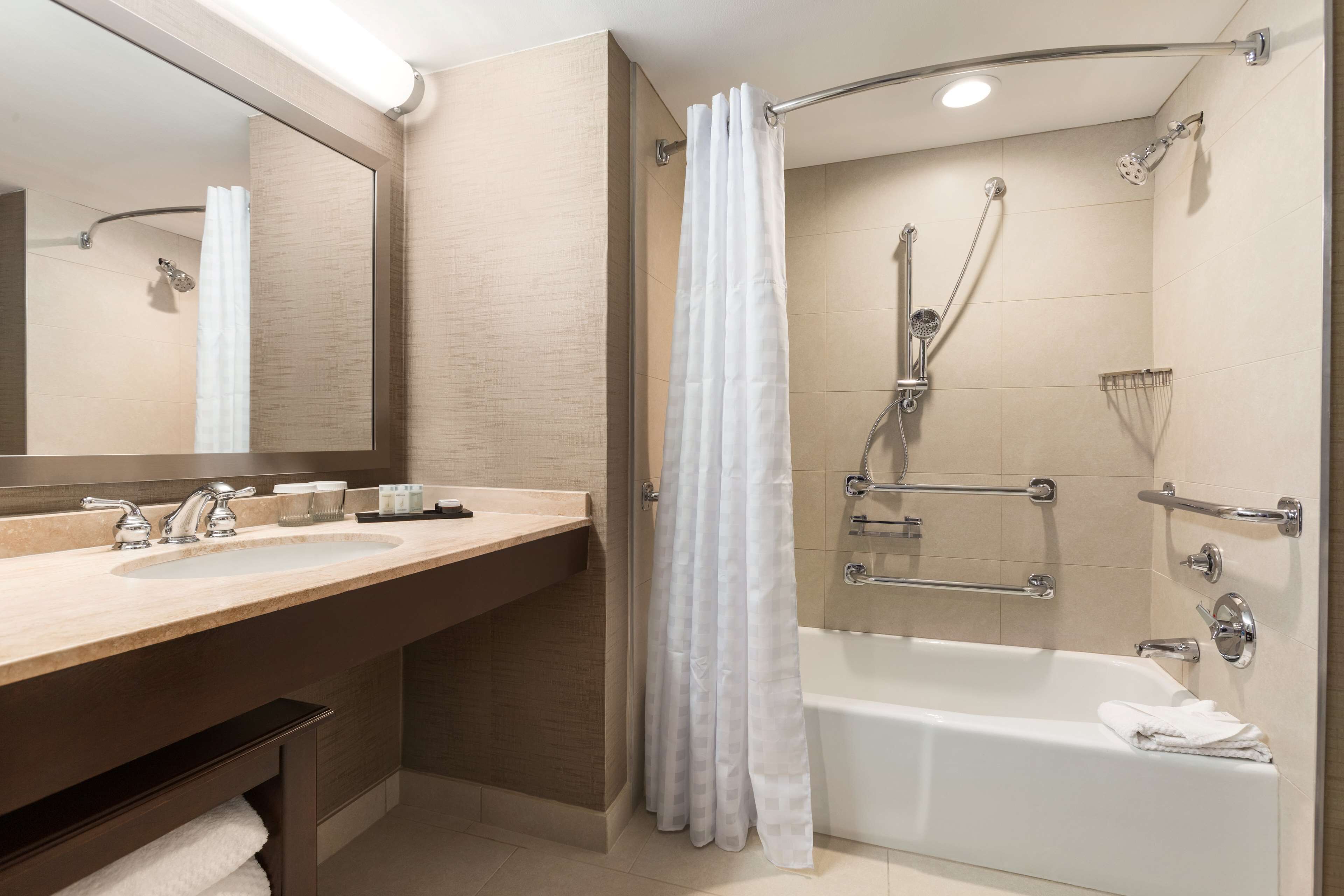 A modern bathroom with a bathtub, shower, and dual sinks.