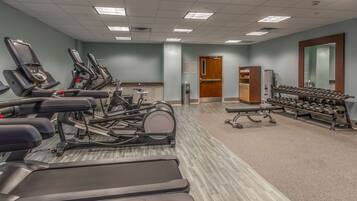 A gym with treadmills, elliptical machines, and free weights.