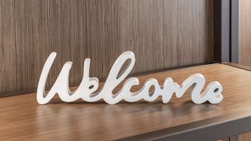 Een houten plank met een wit 'Welcome'-bord.