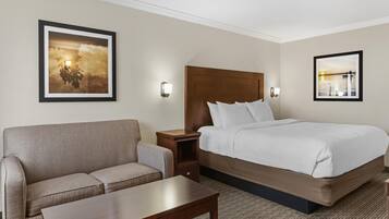A hotel room with a bed, a sofa, a nightstand, and two wall-mounted lamps.