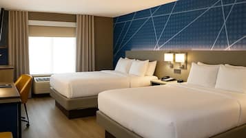 A hotel room with two beds, a desk, a chair, and a large window with curtains.
