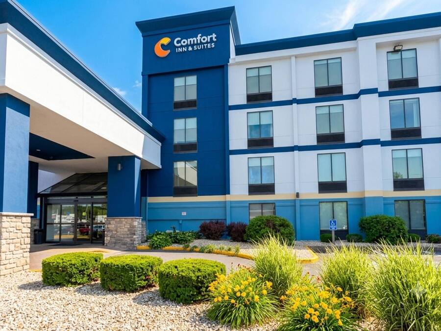 A Comfort Inn & Suites building with a blue and white exterior, a covered entrance, and well-maintained landscaping.